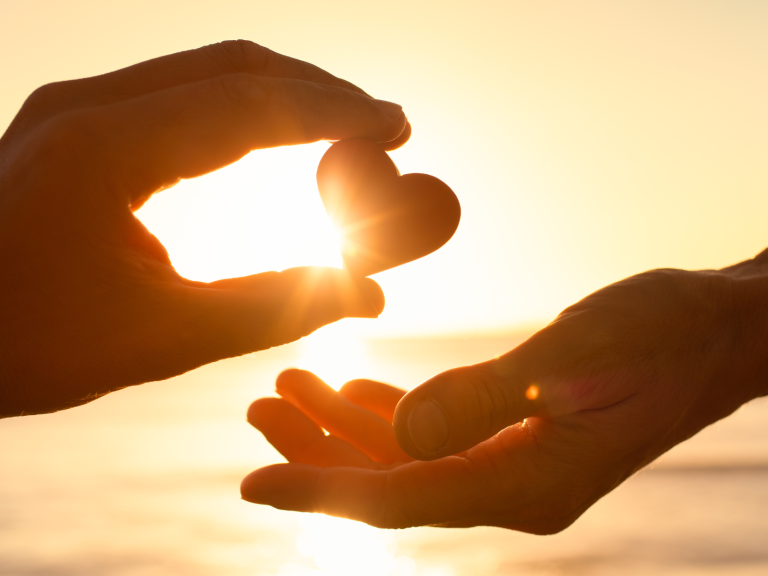 person handing a heart shaped item to another person